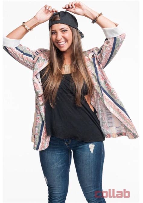 A Woman Is Posing With Her Hands On Her Head While Wearing Jeans And A Black Top