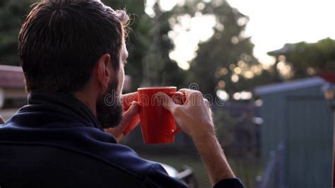 Man Drinks Hot Steaming Coffee Facing Away Suburban Setting Early