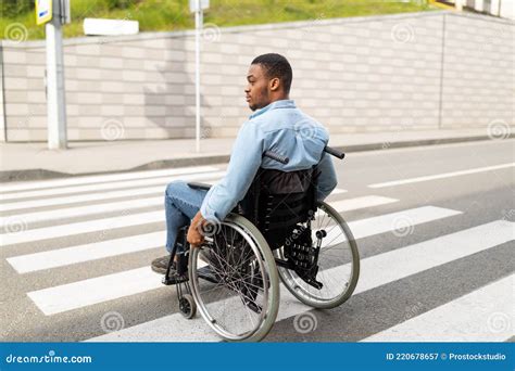 Young Disabled Black Man In Wheelchair Using Crosswalk Outdoors