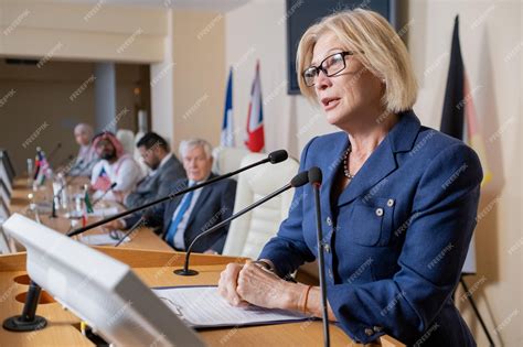 Premium Photo Mature Blond Delegate In Formalwear Speaking In Microphone