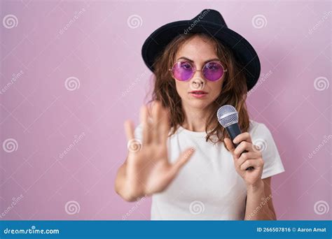 Beautiful Brunette Woman Singing Song Using Microphone With Open Hand