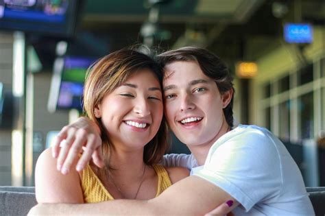 Happy Young Multiracial Couple Hugging While Resting In Cafe · Free