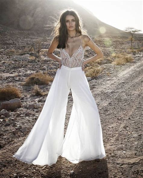 A Woman Standing In The Middle Of A Dirt Road With Her Hands On Her Hips