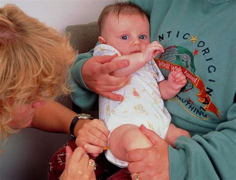 Baby Receiving Dpt Vaccination In Leg Photograph By Simon Fraser