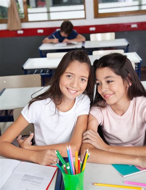 Écolière S Asseyant Au Bureau Avec Des Camarades De Classe Dans A Image Stock Image Du Enfant