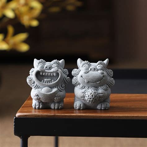 Two Small Figurines Sitting On Top Of A Wooden Table