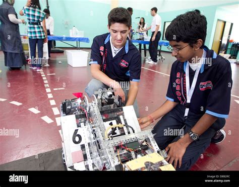 Multi-ethnic group of high school robotics club students give a ...