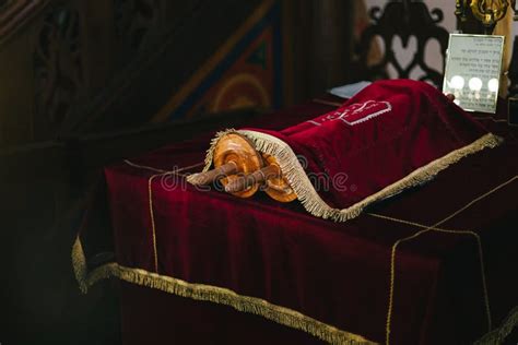 Torah Scrolls On The Table Covered With Red Cloth And Paper With Hebrew