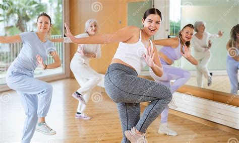 Group Of Energetic Young Mature Female Dancers Dancing With Knee Lift