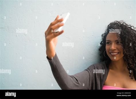 Portrait Of Afro Woman Taking Selfies With Her Mophile Phone Against