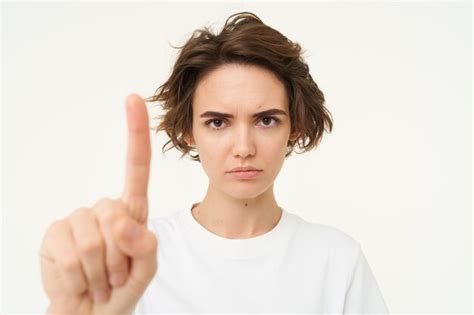 Premium Photo Close Up Of Serious Young Woman Shows One Finger Stop