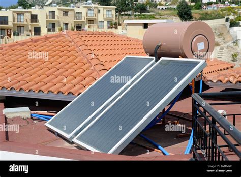 A Solar Water Heating Panel With Water Tank On The Roof Of A Villa In