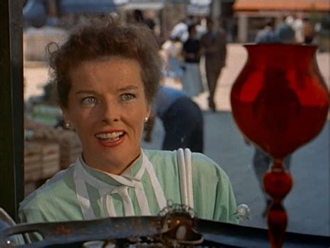 A Woman Sitting In The Driver S Seat Of A Car With An Orange Vase