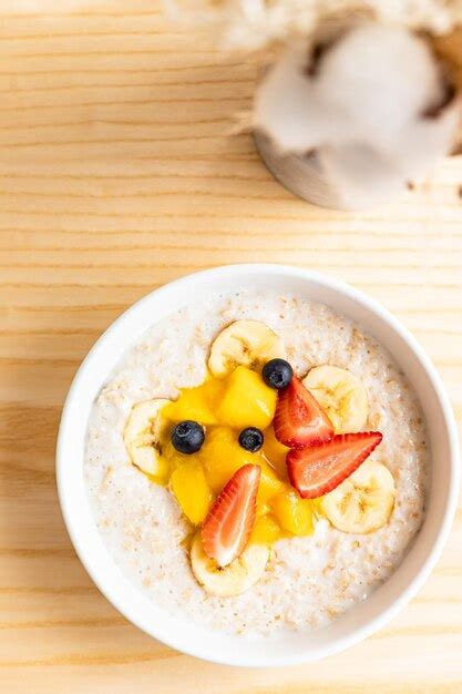 Premium Photo Oatmeal Porridge With Berries Banana And Mango In Bowl