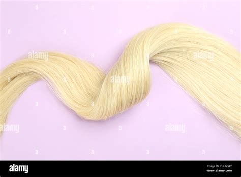 A Lock Of Blonde Female Hair On A Purple Background Stock Photo Alamy