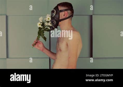 Faceless Shirtless Man In Gas Mask Smelling Flowers Side View Of Unrecognizable Male With Naked