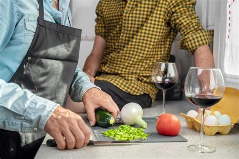 Cerca de una pareja gay irreconocible en la cocina están cocinando la cena juntos en casa Foto