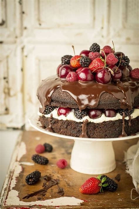 A Birthday Cake With Chocolate Frosting And Berries On Top That Says