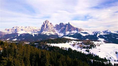 Uma paisagem montanhosa neve e árvores em primeiro plano e um céu