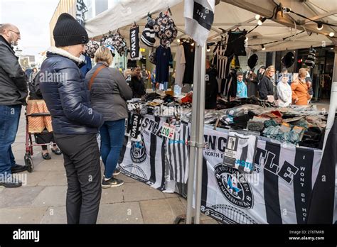 People Shopping At A Market Stall Selling Football Team Themed Items In