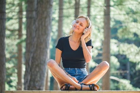 Une fille blonde heureuse souhaite tout en écoutant de la musique sur un casque sur fond de