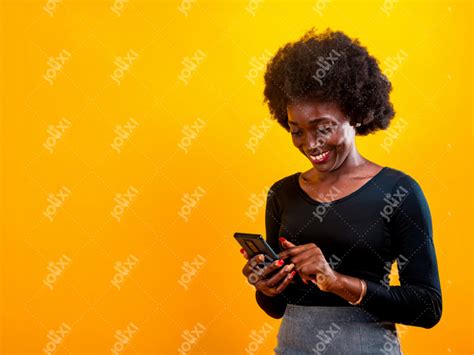 Jeune Femme Africaine Souriante Manipulant Son T L Phone Sur Un Fond