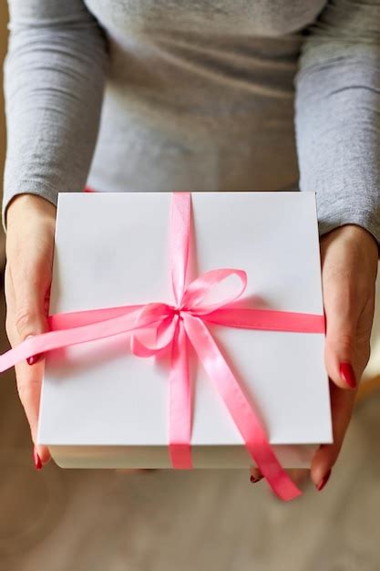 Premium Photo Woman Hands Holding A White Present Box With Pink