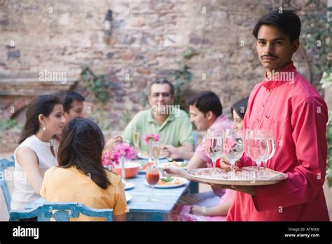 Portrait Of A Waiter Serving Water To Guests Stock Photo Alamy