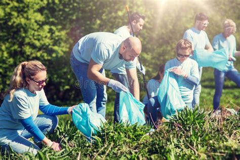 Grupo De Voluntarios Felices Que Llevan A Cabo Las Manos Al Aire Libre