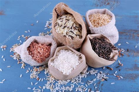 Different Types Of Rice In Sacks On Wooden Background Stock Photo