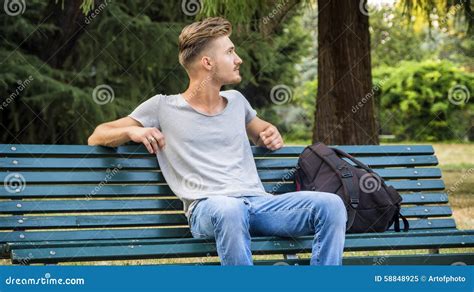 Hübscher Blonder Junger Mann Der Auf Parkbank Sitzt Stockbild Bild