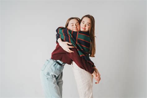 Premium Photo Young Lesbian Couple Embracing Against Gray Background