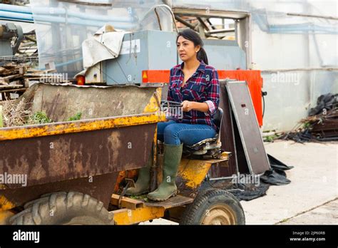 latin american woman farmer driving  mini dump truck drives