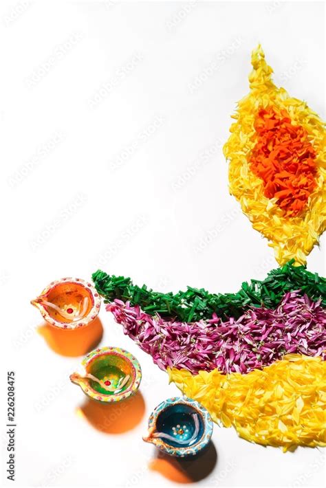 Diwali Rangoli made in shape of Diya with colorful flowers Stock Photo ...