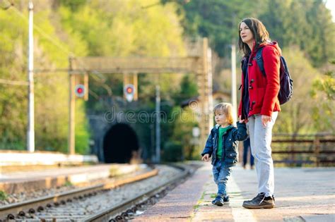 Young Mother And Her Toddler Son On A Railway Station Mom And Little