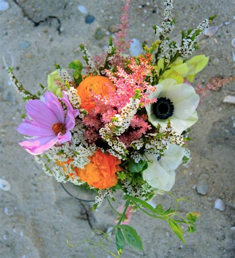 A bride's wildflower bouquet with cheerful pastel colors of purple ...