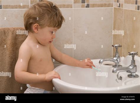 Niño Niño veintidós meses lavarse las manos en el lavabo en el baño