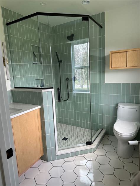 A Bathroom With Green Tiled Walls And Flooring Including A Walk In