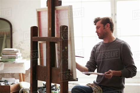 Male Artist Working On Painting In Studio Stock Photo Dissolve