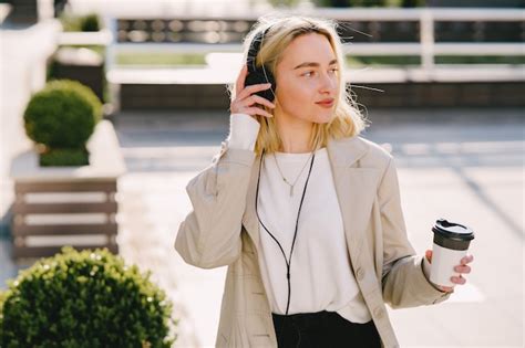 Blonde Se Promène Dans La Ville D été Avec Une Tasse De Café Photo Gratuite