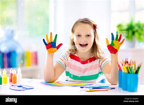 Kids paint. Child painting in white sunny study room. Little girl ...