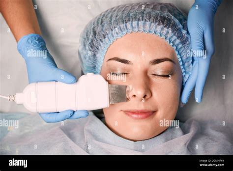 Close Up Of Beautician Hands Using Ultrasonic Scrubber While Cleaning