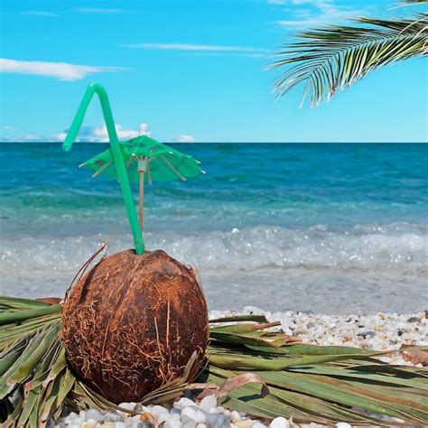 Premium Photo Coconut With Straw And Umbrella Under A Palm Branch