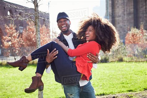 Man carrying woman and laughing - Stock Photo - Dissolve