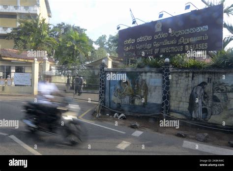 A Motorcycle Past In Front Of Sri Lankas National Institute Of