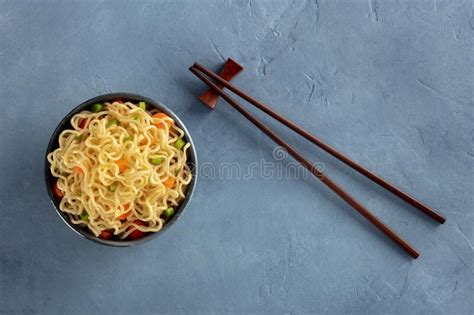 Instant Noodles Bowl With Carrot And Scallions With Chopsticks Stock