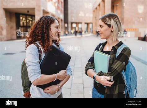 Two young students talking together in the college Stock Photo - Alamy