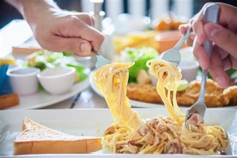 Premium Photo Cropped Hands Of People Eating Noodles