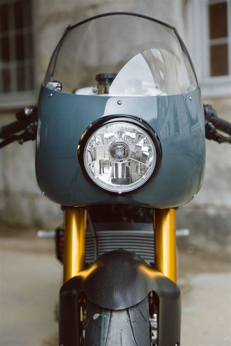 The Front End Of A Motorcycle Parked In A Garage With Its Lights On And