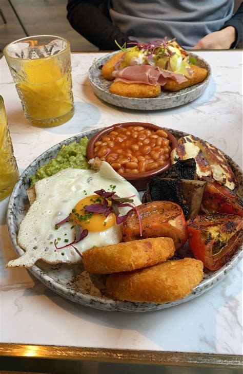 Two Plates Filled With Different Types Of Food On A Table Next To